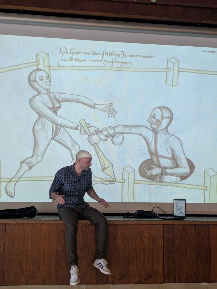 Maxence Favre en conférence devant une planche de Hans Talhoffer projetée